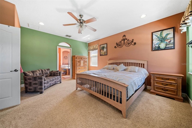 bedroom featuring ceiling fan, light carpet, and ensuite bathroom