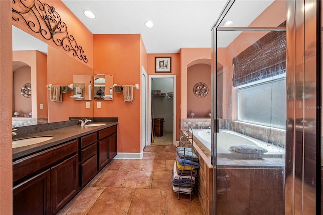 bathroom with tiled tub and vanity