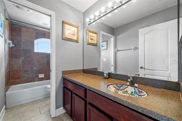 full bathroom with toilet, tile patterned floors, tiled shower / bath, vanity, and a textured ceiling