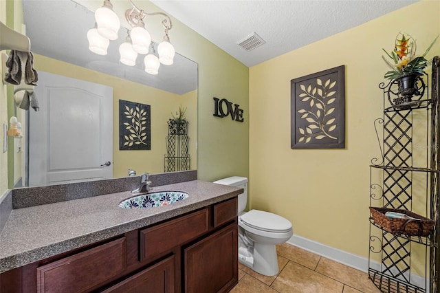 bathroom featuring toilet, tile patterned floors, vanity, a textured ceiling, and an inviting chandelier