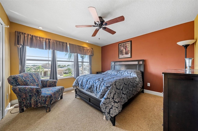 carpeted bedroom featuring a textured ceiling and ceiling fan