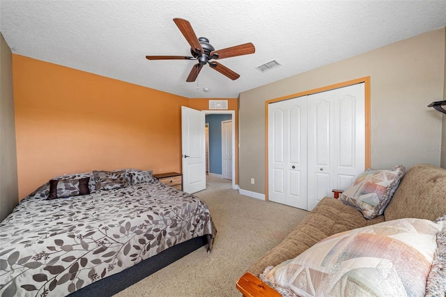 bedroom featuring a closet, ceiling fan, light colored carpet, and a textured ceiling