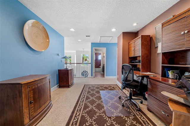 home office with a textured ceiling and light colored carpet