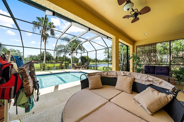 view of swimming pool featuring a water view, ceiling fan, glass enclosure, and a patio area