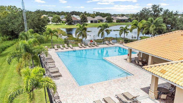 view of pool with a water view and a patio