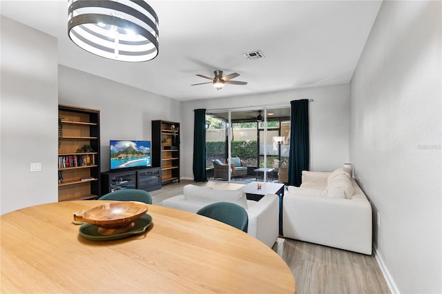 dining space with ceiling fan and light hardwood / wood-style flooring