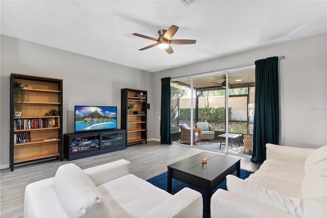 living room featuring ceiling fan and light hardwood / wood-style floors