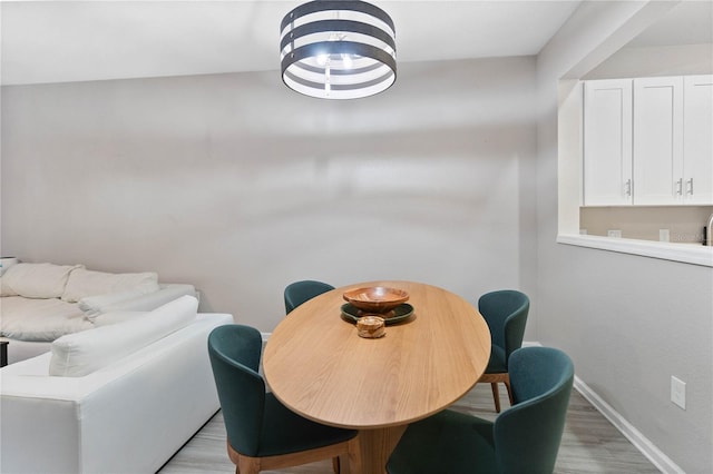 dining space featuring light hardwood / wood-style flooring and a chandelier