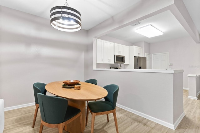 dining space featuring light hardwood / wood-style flooring and a notable chandelier