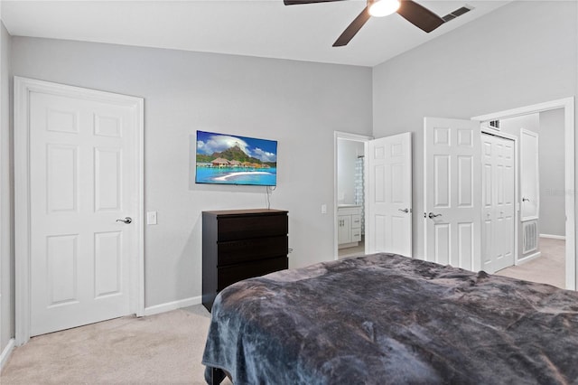 bedroom with lofted ceiling, ceiling fan, light colored carpet, and ensuite bathroom