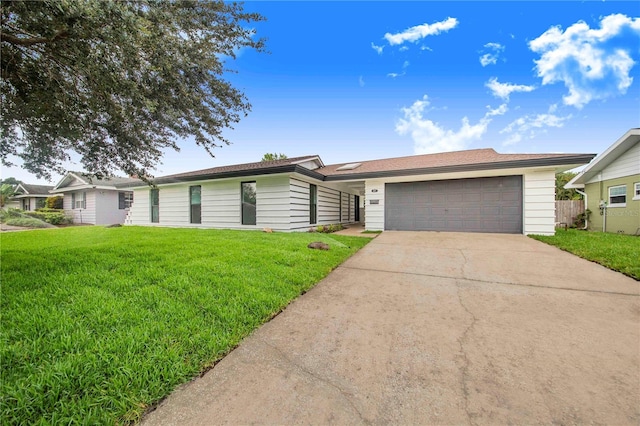 single story home with a garage and a front lawn