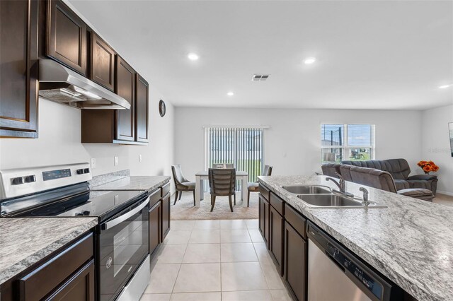 kitchen featuring light tile patterned floors, stainless steel appliances, dark brown cabinets, and sink