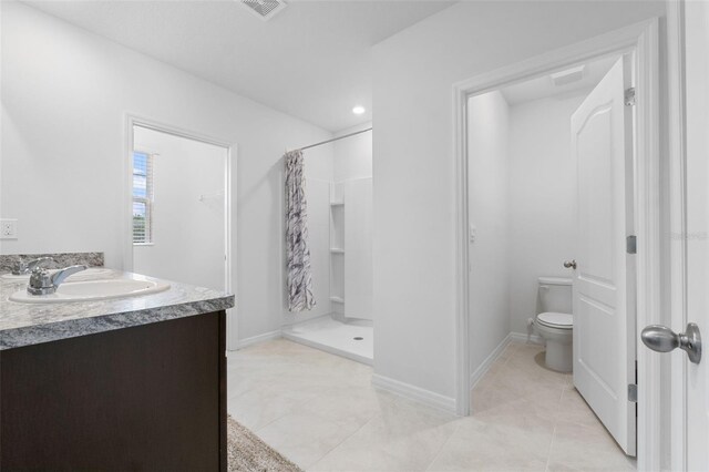 bathroom with curtained shower, tile patterned flooring, toilet, and vanity