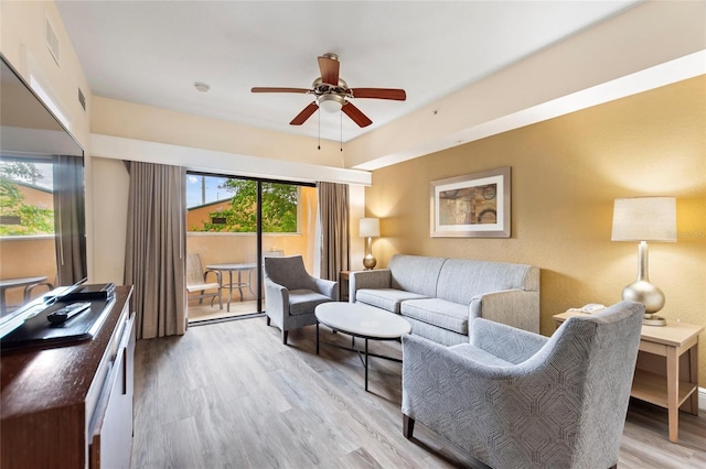 living room featuring ceiling fan and light hardwood / wood-style flooring