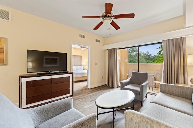 living room featuring ceiling fan and light hardwood / wood-style flooring