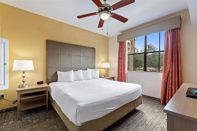 bedroom with dark colored carpet and ceiling fan