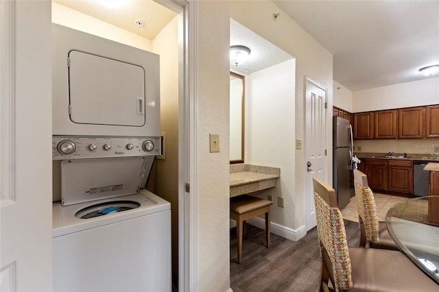 washroom featuring hardwood / wood-style floors and stacked washer and clothes dryer