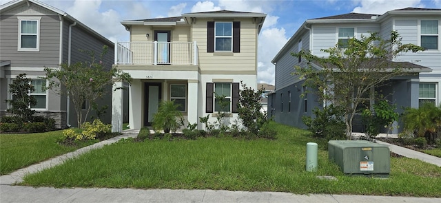 view of front facade with a balcony and a front yard