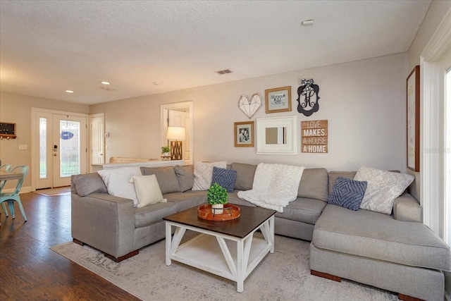 living room featuring light hardwood / wood-style floors and a textured ceiling