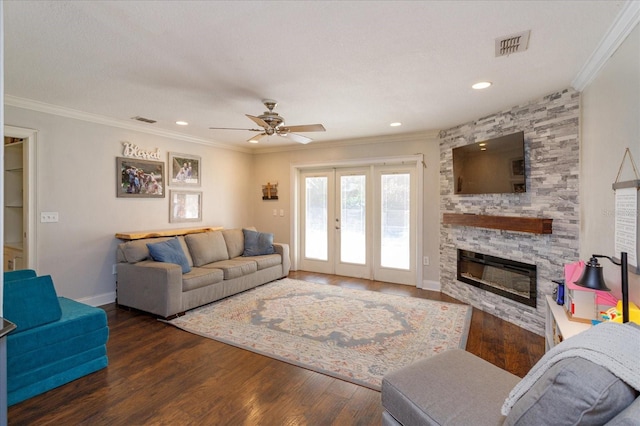 living room featuring ceiling fan, a fireplace, and dark wood-type flooring