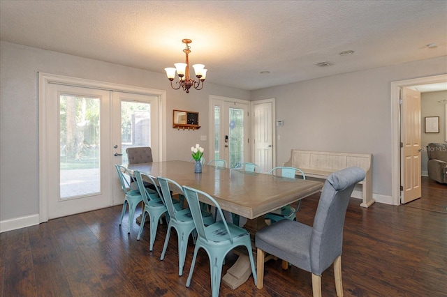 dining space featuring french doors, a notable chandelier, dark hardwood / wood-style floors, and a textured ceiling