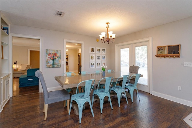 dining room with a notable chandelier, a textured ceiling, and dark wood-type flooring