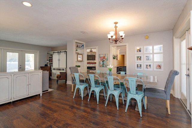 dining room with french doors, an inviting chandelier, dark wood-type flooring, and a textured ceiling