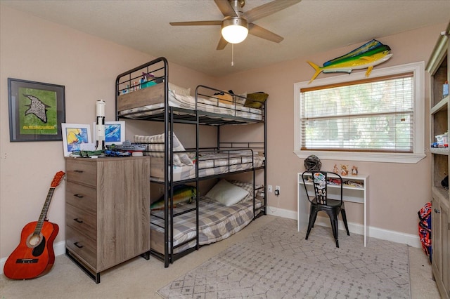 bedroom with a textured ceiling, light carpet, and ceiling fan