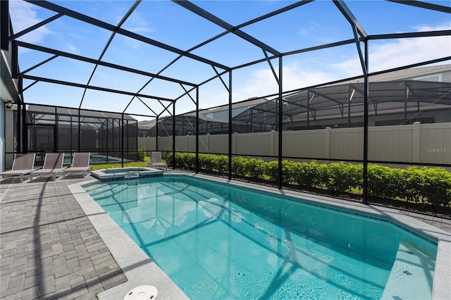 view of swimming pool with glass enclosure and a patio area