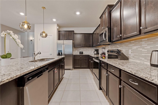 kitchen featuring sink, backsplash, appliances with stainless steel finishes, decorative light fixtures, and dark brown cabinetry