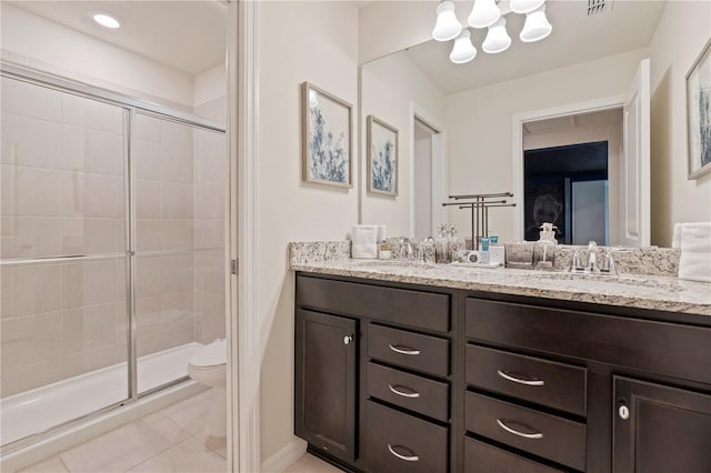 bathroom with vanity, toilet, and a shower with door