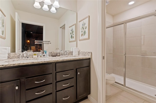 bathroom featuring vanity, tile patterned flooring, toilet, and a shower with door