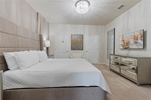 carpeted bedroom with a chandelier and a textured ceiling