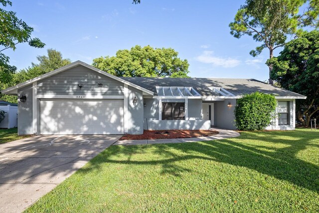 ranch-style house with a garage and a front lawn