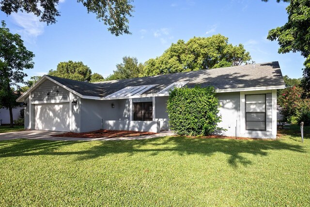 ranch-style home with a garage and a front lawn