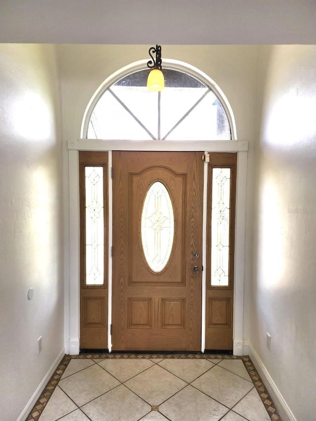 entryway featuring light tile patterned floors, baseboards, and plenty of natural light