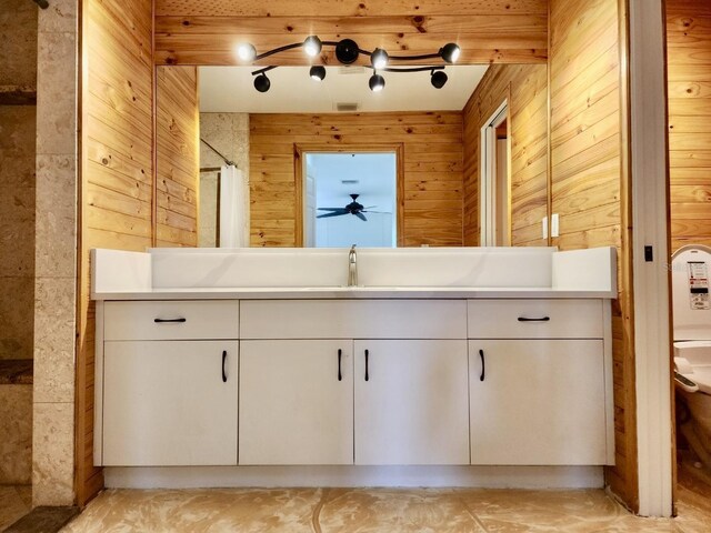 bathroom with vanity, a shower with curtain, wooden walls, and ceiling fan