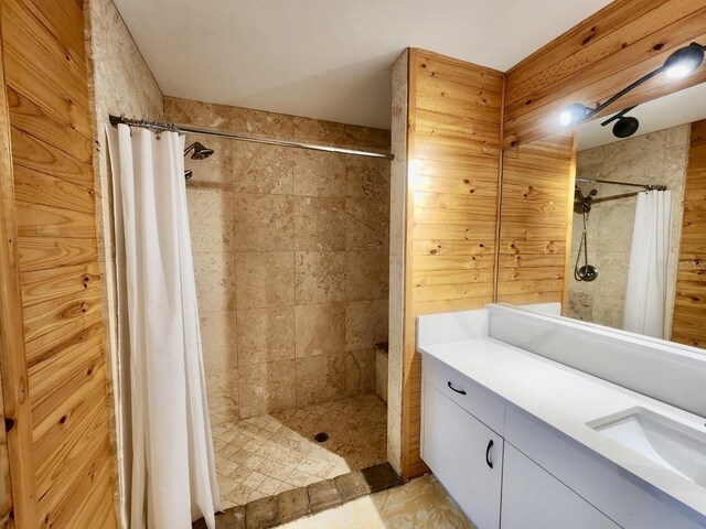 bathroom with vanity, curtained shower, and wood walls