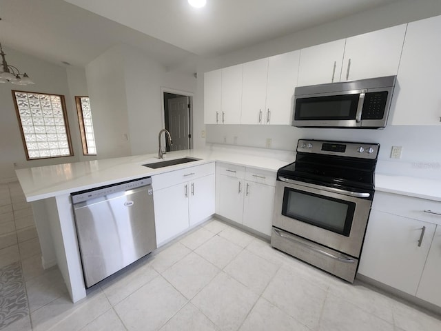 kitchen with a sink, appliances with stainless steel finishes, a peninsula, and light countertops