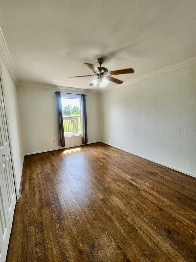 empty room featuring ornamental molding, dark hardwood / wood-style flooring, and ceiling fan