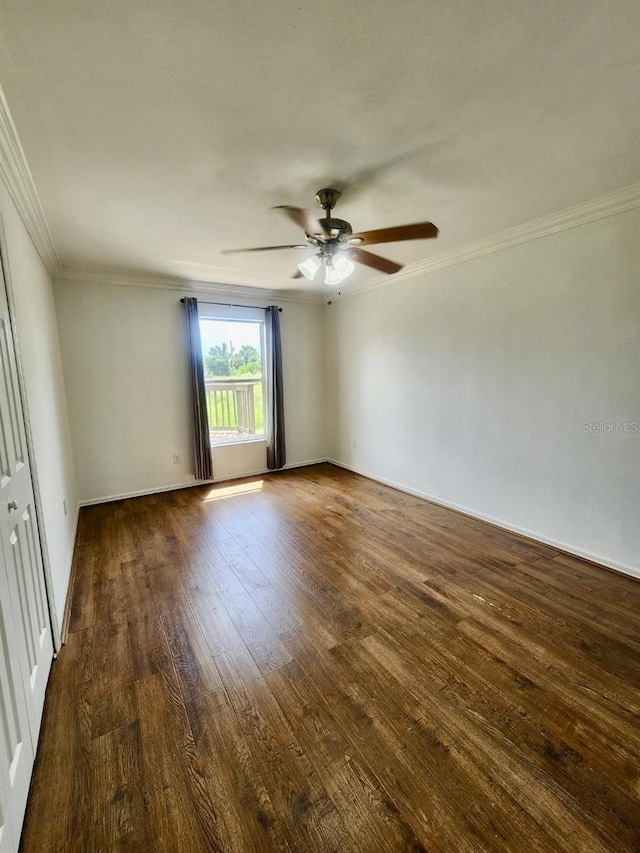 empty room with baseboards, ceiling fan, dark wood-style flooring, and crown molding