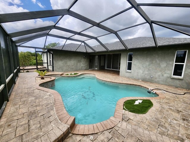 view of swimming pool with glass enclosure and a patio