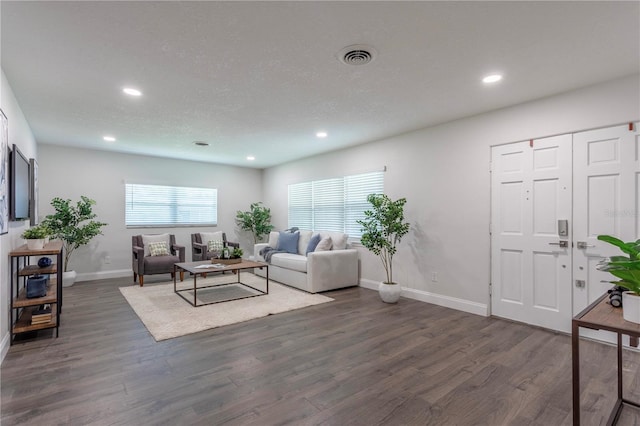 living room featuring a textured ceiling, dark hardwood / wood-style floors, and plenty of natural light