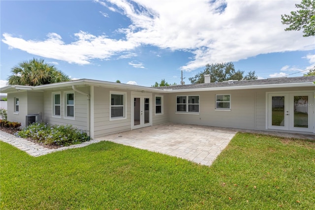 rear view of house featuring central air condition unit, a patio area, french doors, and a lawn