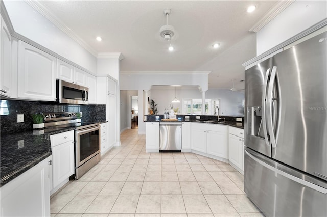 kitchen with crown molding, sink, light tile patterned floors, white cabinetry, and stainless steel appliances