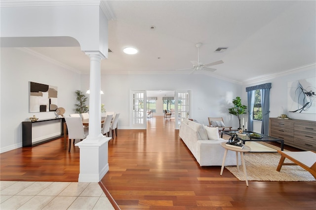 living room featuring decorative columns, wood-type flooring, ceiling fan, crown molding, and french doors