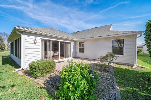 back of property featuring a patio area and a lawn