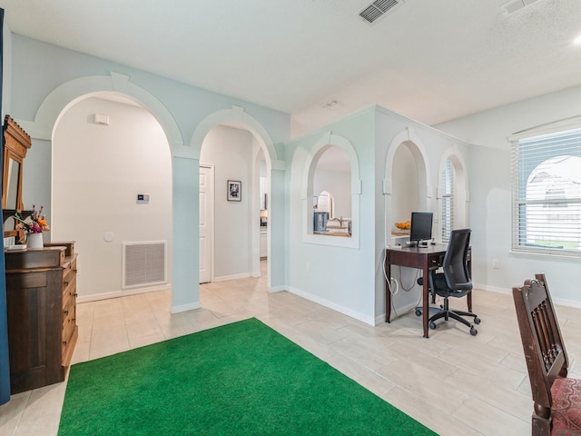 entryway with a textured ceiling and tile patterned flooring