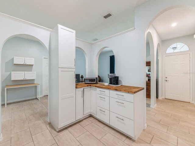 kitchen with white cabinetry and wooden counters