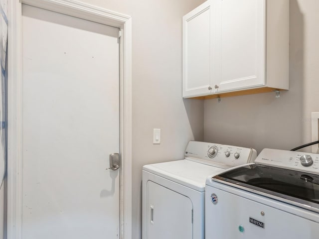 washroom with cabinets and washing machine and dryer